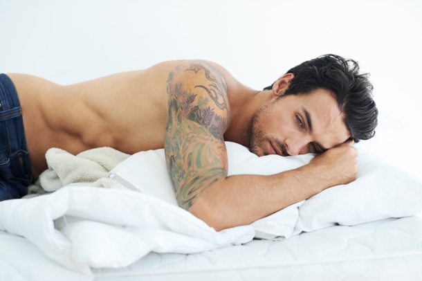 Man with Tattoos Lying in Bed